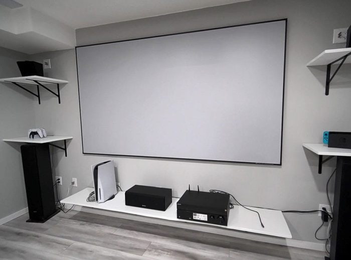 Elite Screens Motorized Projector Screen Large white motorized projector screen in a modern home theater setup.