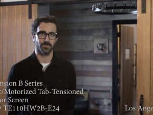 CineTension B Series motorized tab-tensioned projector screen in a modern home theater.