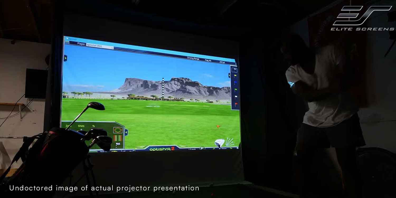 Outdoor projector screen displaying a scenic landscape with mountains and green fields.