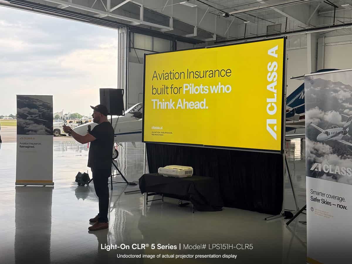 Large aviation insurance presentation screen at an event, showcasing pilot-focused coverage solution.