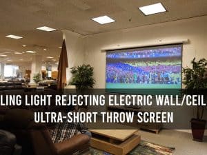 Electric wall/ceiling ultra-short throw projector screen for ceiling light rejection.