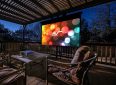 Outdoor projector screen on a patio with seating, perfect for home theater setups.